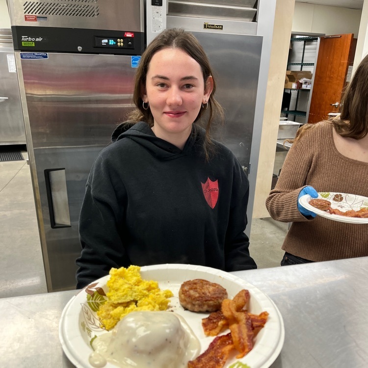 student serving breakfast